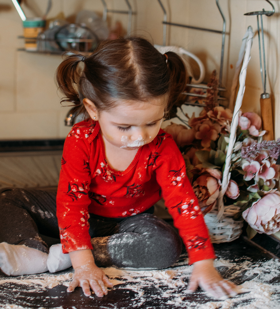 Flour Sensory Play for Toddlers. Easy flour sensory play activity for babies. Cute little girl sits on kitchen table and plays with flour