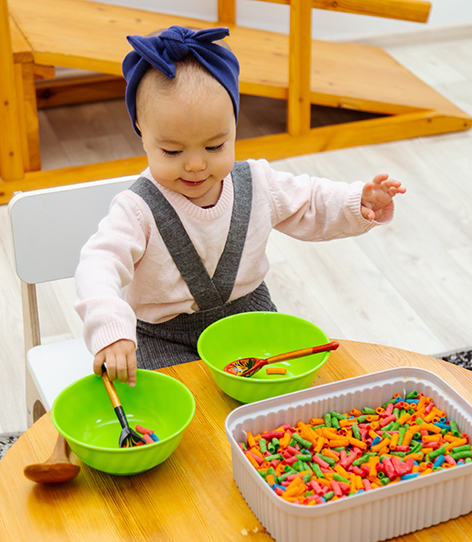 toddler-playing-sensory-game-sorting-colored-pasta