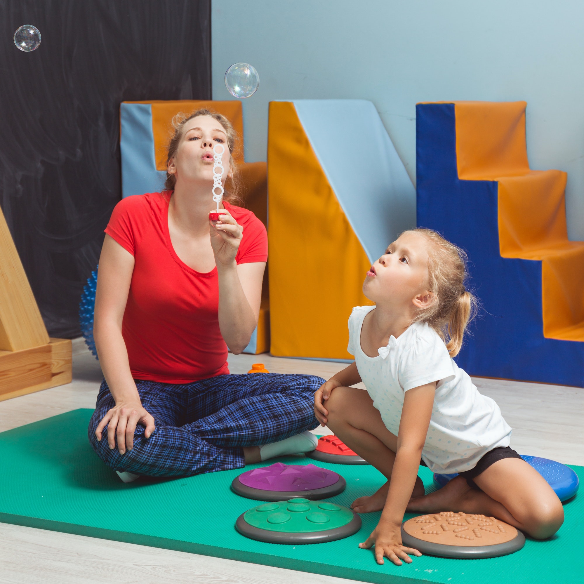 Child blowing bubbles during sensory integration therapy